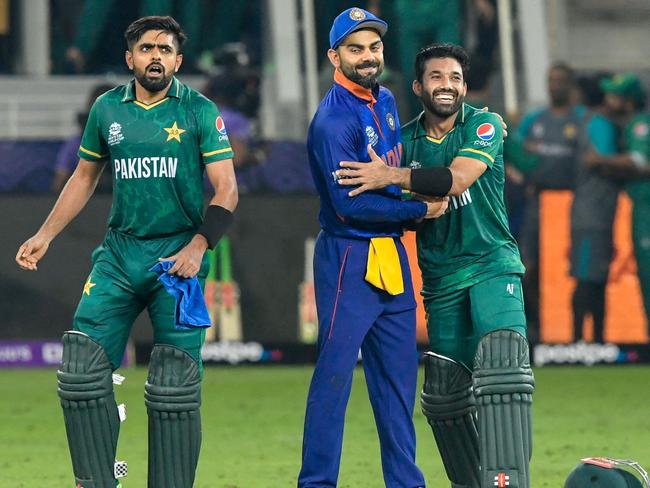 India's captain Virat Kohli (C) congratulates his Pakistan's counterpart Babar Azam (L) and Mohammad Rizwan following their victory during the ICC menâs Twenty20 World Cup cricket match between India and Pakistan at the Dubai International Cricket Stadium in Dubai on October 24, 2021. (Photo by Aamir QURESHI / AFP)