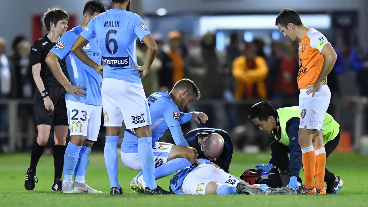 Luke Brattan of City is seen being attended to by medical staff after he was injured during the FFA Cup Round of 32 match between the Brisbane Roar and Melbourne City