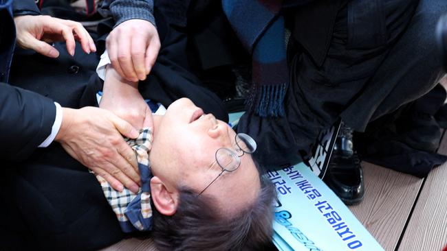 South Korean opposition party leader Lee Jae-myung falls after being attacked by an unidentified man during his visit to Busan, South Korea, on Tuesday. Picture: Reuters 