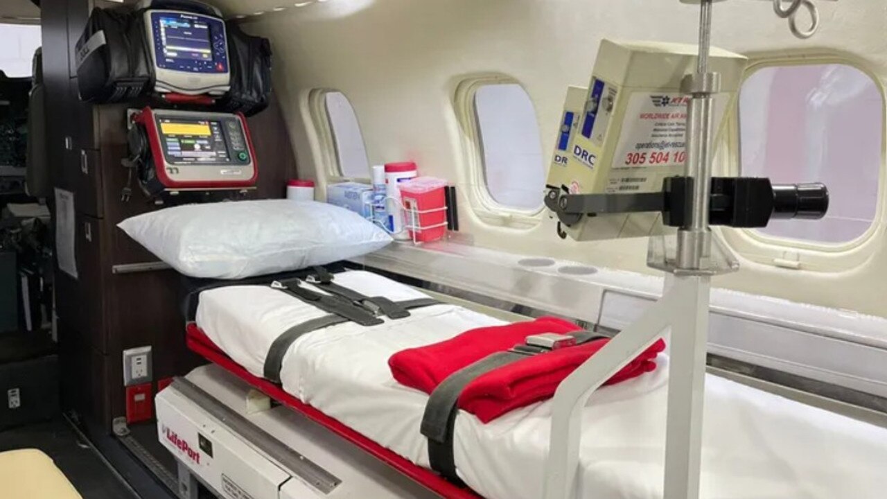 Photos show a stretcher covered in a white sheet and surrounded by various pieces of medical equipment used to track vitals and care for a patient.