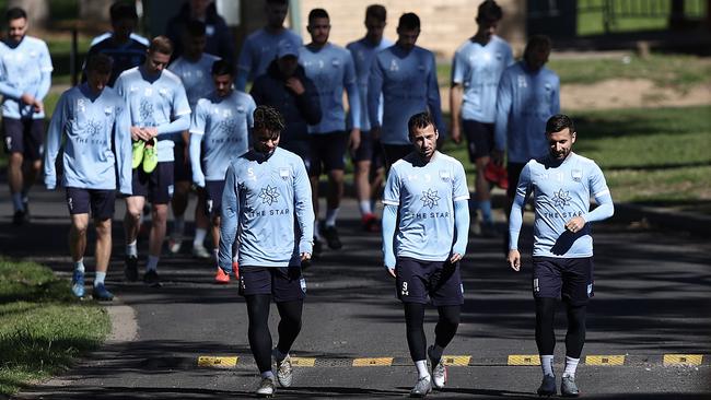 Sydney FC’s Alexander Baumjohann, Adam Le Fondre and Kosta Barbarouses lead their team to the training pitch at Macquarie Uni. Picture: Getty Images