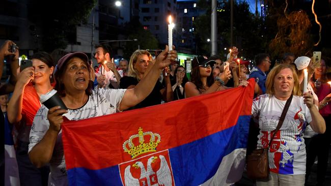 TOPSHOT - Members of the local Serbian community gather for a vigil outside a hotel where Serbia's tennis champion Novak Djokovic is reported to be staying