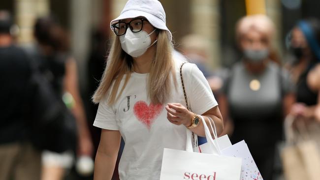 SYDNEY, AUSTRALIA - DECEMBER 24: A shopper walks in Sydney's CBD on December 24, 2021 in Sydney, Australia. New COVID-19 rules have come into effect as of midnight, with masks required in indoor settings. The new rules have been introduced in an effort to slow the spread of the Omicron variant, following a surge of new COVID-19 cases across the state. From Monday 27 December, QR code check ins will once again be compulsory, including for hospitality and retail, while hospitality venues, including pubs, clubs, restaurants and cafes will move to 1 person per 2 sqm rule indoors, with no density limit for outdoor settings. (Photo by Jason McCawley/Getty Images)