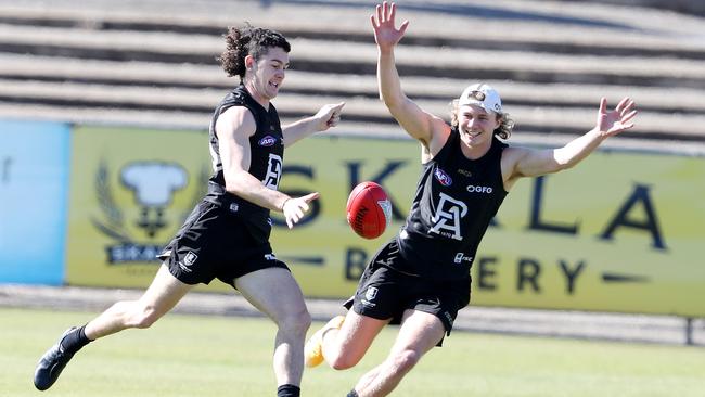 Darcy Byrne-Jones goes to kick as Xavier Duursma tries to smother at Port Adelaide training on Alberton Oval this week. Picture: Sarah Reed