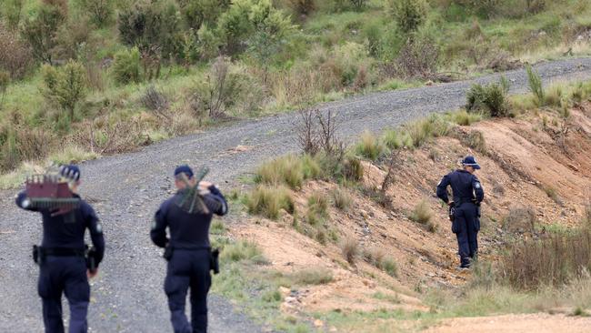 \Police pictured doing a line search closer the a crime scene on a property off Hazelton Road in Bungonia, as part of the ongoing investigation. Picture: NCA NewsWire / Damian Shaw