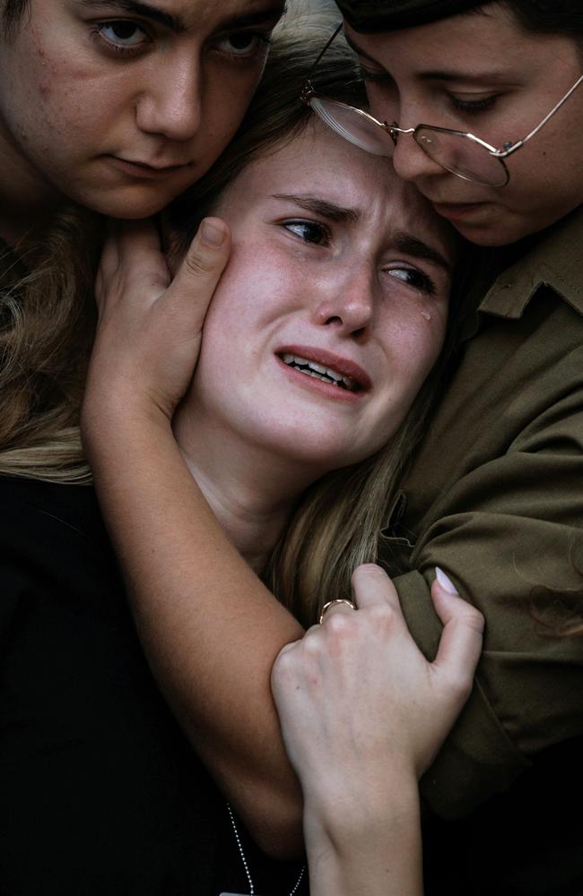 The girlfriend of the late First Sergeant Itay Saadon, Liza, is consoled during his funeral at Misgav cemetery in Israel. Picture: Getty Images