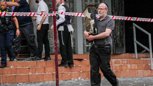 A member of the Jewish community recovers an item from the Adass Israel Synagogue. Picture: Getty Images