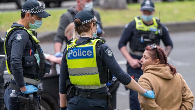 Police question a woman at Treasury Gardens. Picture: Tony Gough