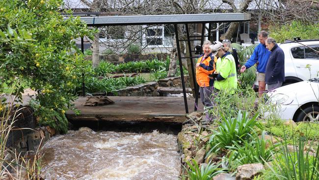 Water rushes past a house close to First Creek on Waterfall Gully Road. Picture: Russell Millard Photography