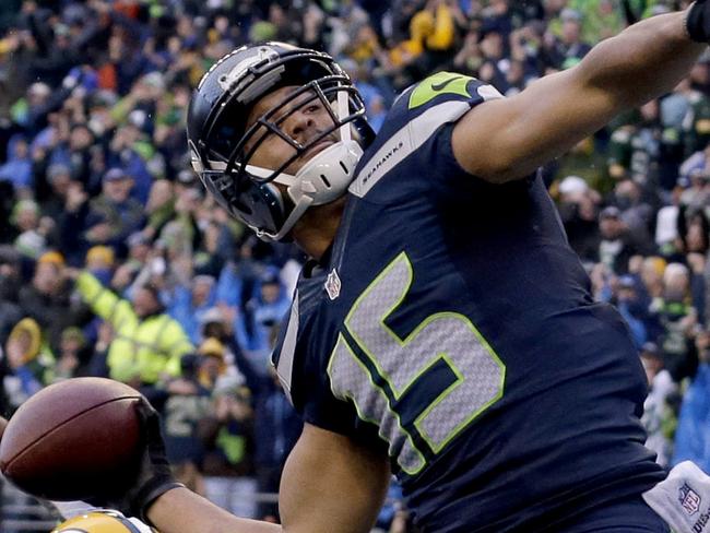 FILE - In this Sunday, Jan. 18, 2015, file photo, Seattle Seahawks wide receiver Jermaine Kearse (15) throws the ball into the stands after scoring the game-winning touchdown against the Green Bay Packers during overtime of the NFC championship NFL football game in Seattle. Kearse was having an NFC championship game to forget until the final play. That's when the Seahawks receiver added yet another memorable postseason touchdown to his resume. (AP Photo/Jeff Chiu, File)
