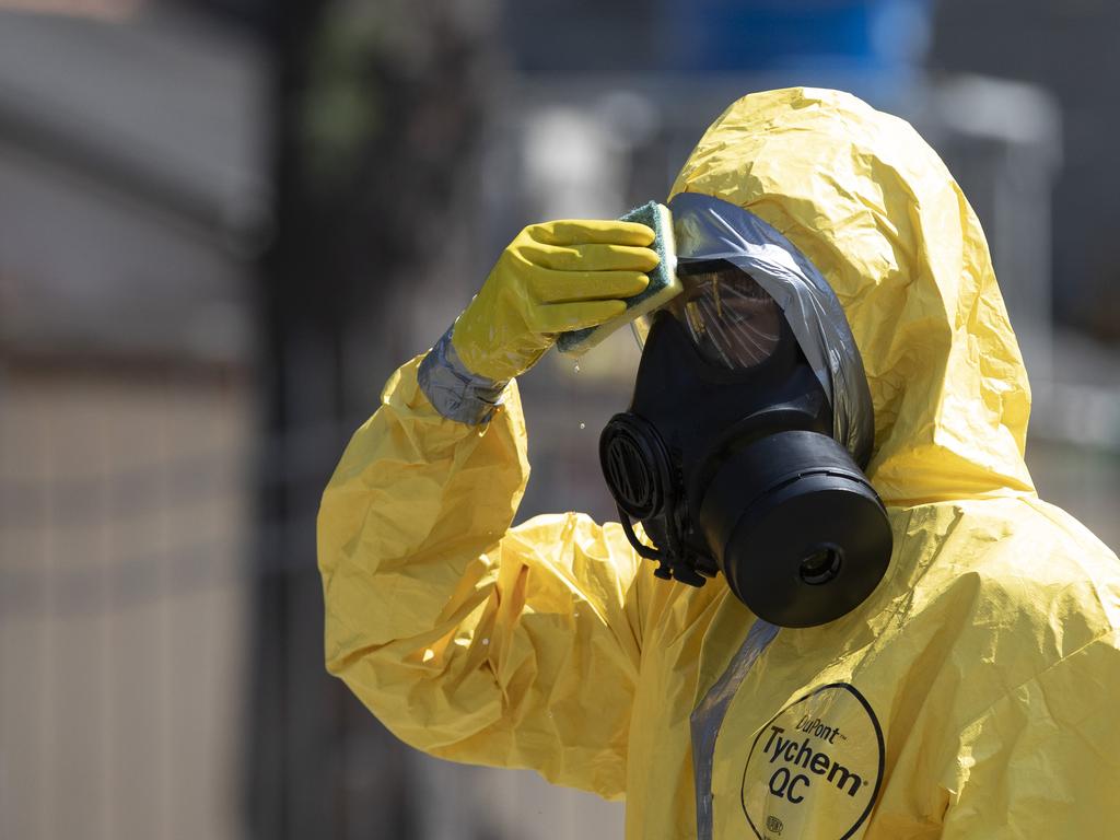 A Brazilian soldier in protective gear wipes his mask with a sponge. Picture: Silvia Izquierdo/AP