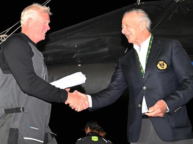 Tony Mutter is presented with the Back Stay flag after crossing the line first to win the 2024 Sydney to Hobart. Picture: Getty Images