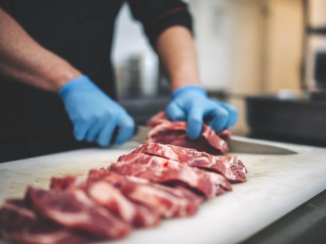 Too much red meat is too much. steak being cut by a butcher