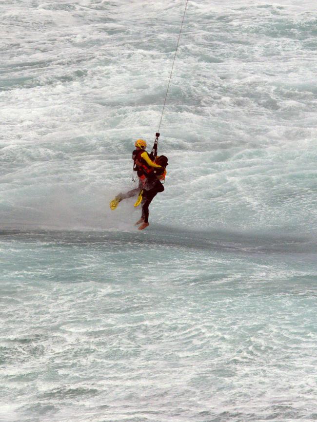 A man is saved from the waters by a rescuer. Picture: Ian McCauley