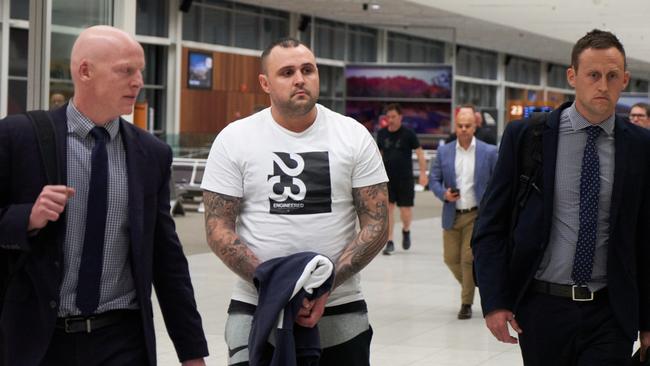 Kyle Lloyd Pryde, centre, arriving at Adelaide Airport in police custody, after being extradited back to SA to face charges for the death of Jason De Ieso.