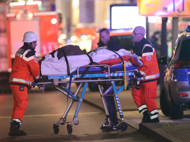 Rescue workers push a person on a stretcher in the area after a lorry truck ploughed through a Christmas market on December 19, 2016 in Berlin, Germany. Picture: Getty