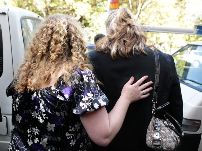 Walsh’s daughter is comforted by her friend leaving NSW Supreme Court at her father’s sentencing for the triple murders.