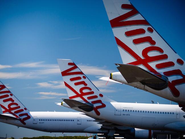 Virgin Australia aircraft are seen parked on the tarmac at Brisbane International airport on April 21, 2020. - Cash-strapped Virgin Australia collapsed on April 21, making it the largest carrier yet to buckle under the strain of the coronavirus pandemic, which has ravaged the global airline industry. (Photo by Patrick HAMILTON / AFP)