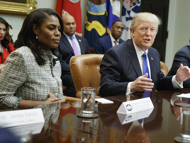 FILE - In this Feb. 1, 2017, file photo, President Donald Trump, center, is flanked by White House staffer Omarosa Manigault Newman, left, and  then-Housing and Urban Development Secretary-designate Ben Carson as he speaks during a meeting on African American History Month in the Roosevelt Room of the White House in Washington. Manigault Newman, who was fired in December, released a new book 
