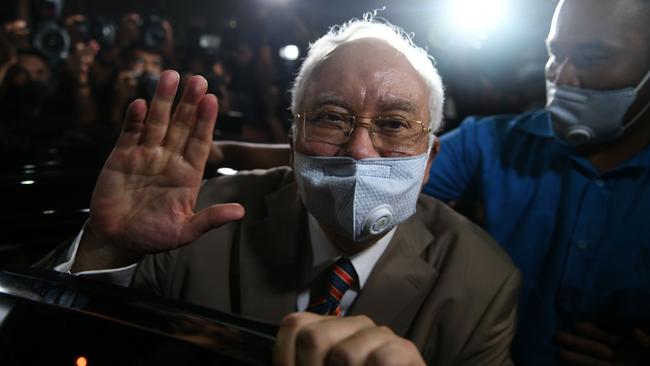 Malaysia's former prime minister Najib Razak waves as he leaves court on Tuesday after he was found guilty in his corruption trial in Kuala Lumpur. Picture: AFP