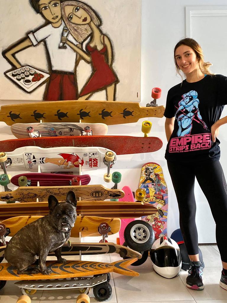 Kat with some of her boards and her skateboard loving french bulldog Vader.