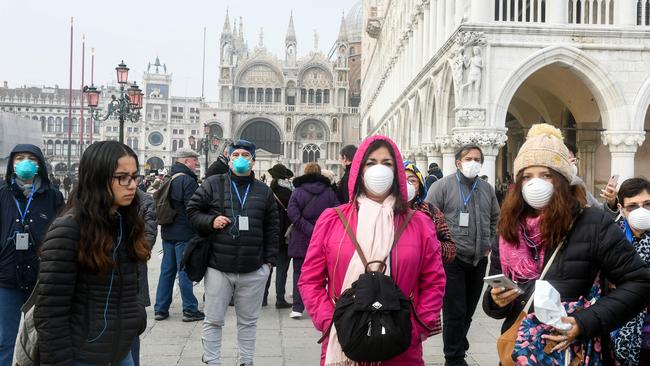 Tourists wearing protective masks while in Venice, as the Australian government warns of travel to Italy. Picture: AFP