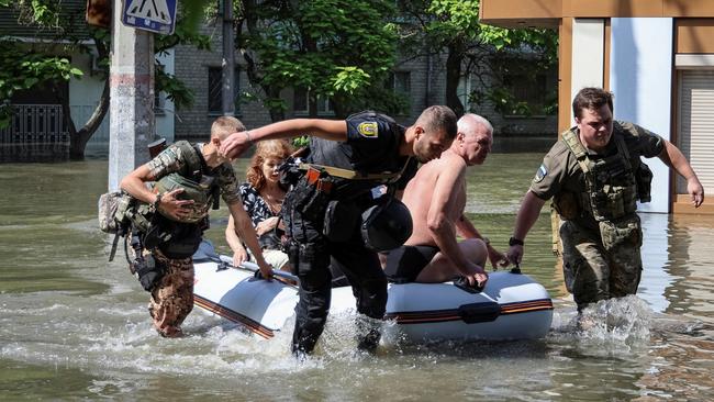 Ukrainian police ferry locals to safety after the Nova Kakhovka dam was breached, leaving tens of thousands stranded. Picture: Reuters