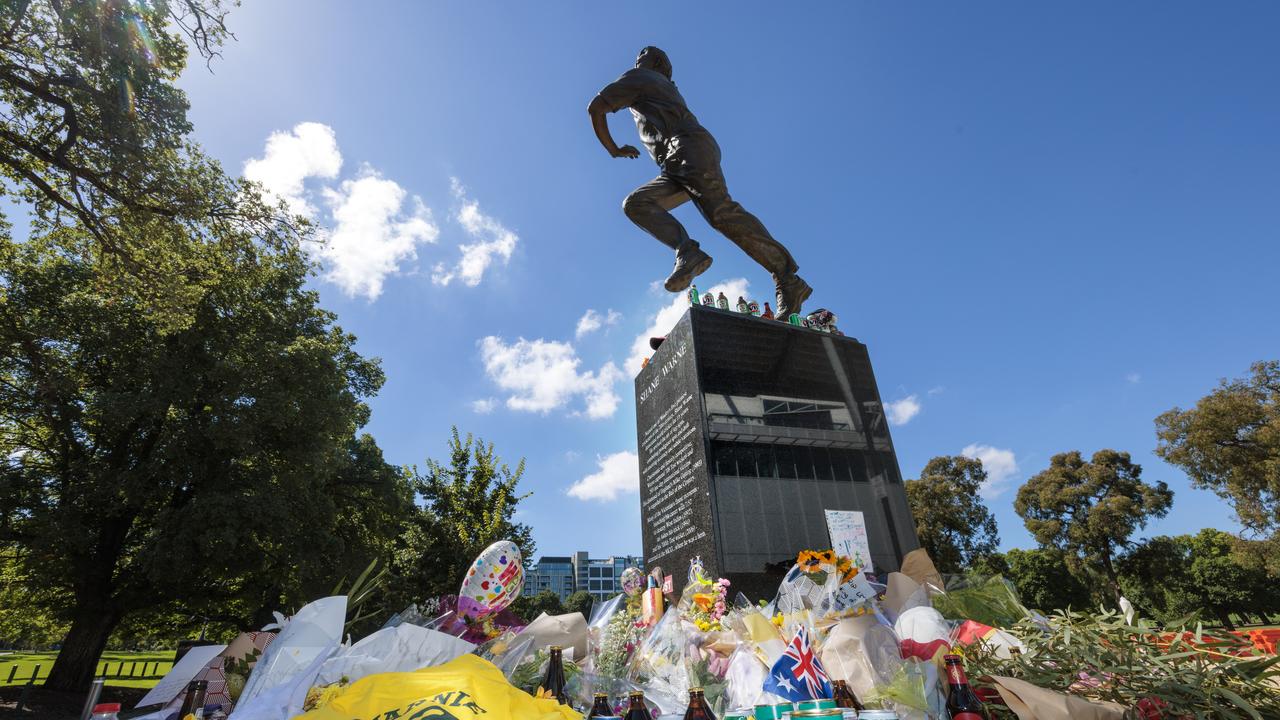 People continue to place flowers and other items at the Shane Warne statue at the MCG days after his death in Thailand. Picture: NCA NewsWire / David Geraghty.