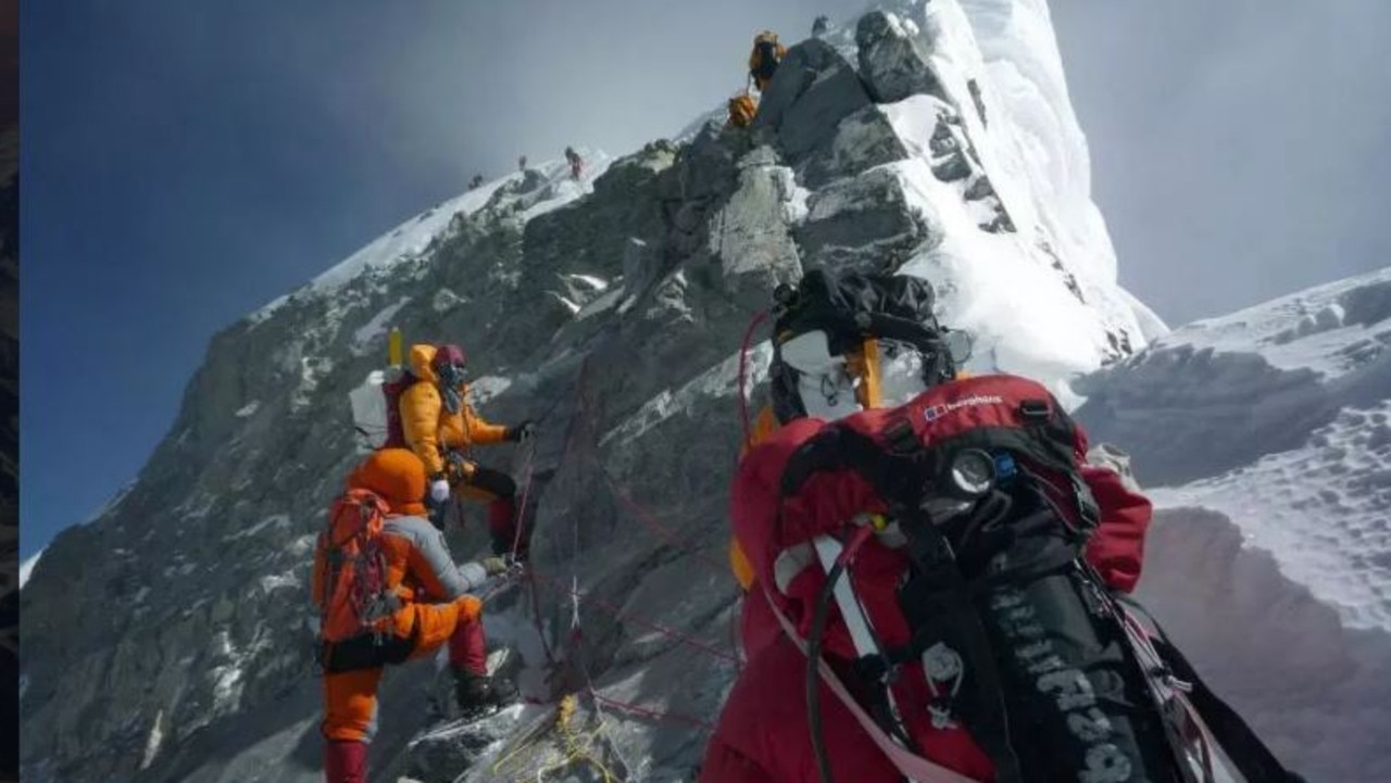 Mountaineers push up past the Hillary Step on the way to the summit of Everest.