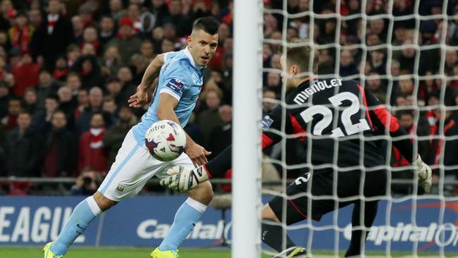 Simon Mignolet (R) saves a shot from Sergio Aguero.