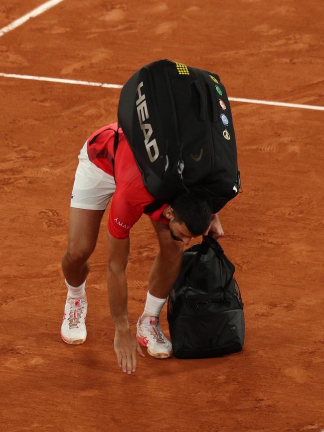 Novak Djokovic picks up some clay from the court after his semi-final defeat. (Photo by Adam Pretty/Getty Images)