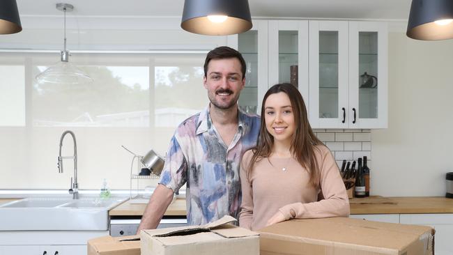 Jarrod Redmond, 23, and Rebecca Michelsen, 21, pose for a photo at their new home today, October 6, 2018. The young couple have successfully bought their first home at in Emu Heights. (AAP Image/David Swift)