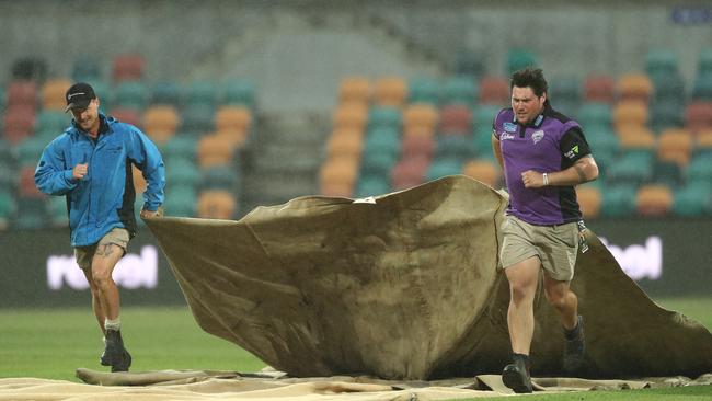 The ground staff bring on rain covers during the Women’s Big Bash League match between the Hobart Hurricanes and the Sydney Sixers at Blundstone Arena last night. Picture: Mark Metcalfe/Getty Images