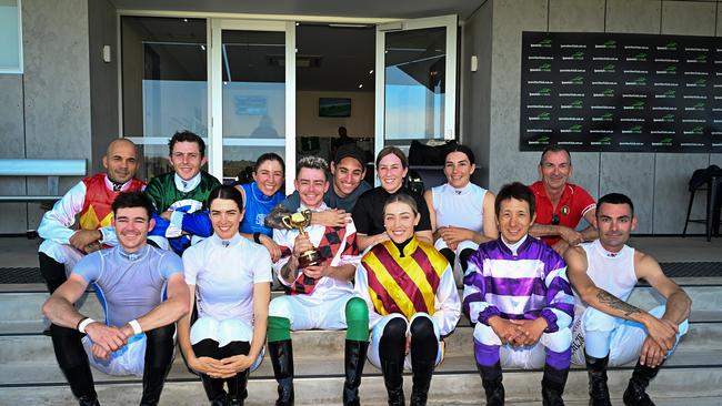 Melbourne Cup-winning jockey Robbie Dolan holds his trophy with fellow riders at Ipswich today. Picture: Grant Peters / Trackside Photography