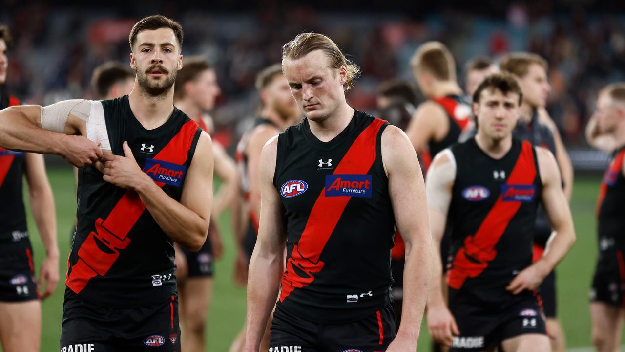 Mason Redman leads a dejected Essendon team off the field after the loss to the Magpies. (Photo by Michael Willson/AFL Photos via Getty Images)