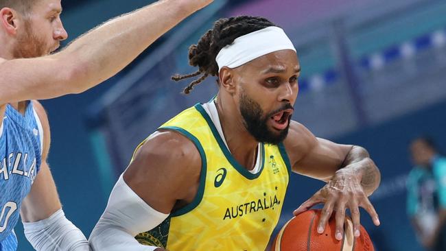 Australia's #05 Patty Mills outflanks Greece's #0 Thomas Walkup in the men's preliminary round group A basketball match between Australia and Greece during the Paris 2024 Olympic Games at the Pierre-Mauroy stadium in Villeneuve-d'Ascq, northern France, on August 2, 2024. (Photo by Thomas COEX / AFP)