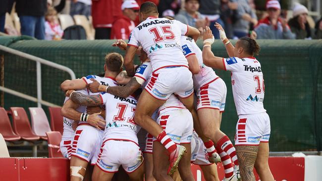 Dragons celebrate with an homage to Piggy Riddell after the match winning try.