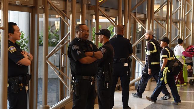 Police keep watch over passengers at Los Angeles International Airport after the US State Department issued a worldwide travel alert warning US citizens of the heightened risks of traveling due to "increased terrorist threats" November 23, 2015 in Los Angeles, California. AFP PHOTO / MARK RALSTON