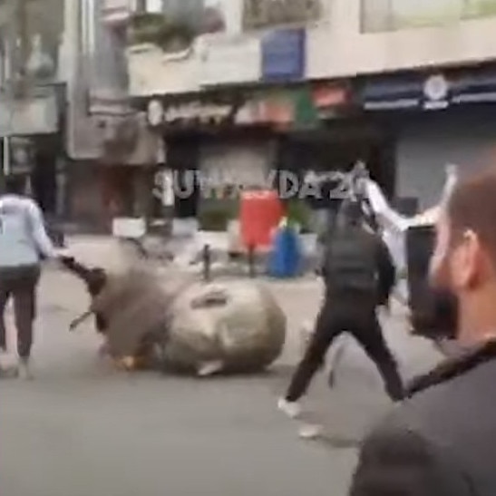 Footage from a video of protesters toppling a statue of Bashar al-Assad’s late father in a Damascus suburb.