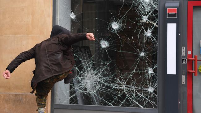 A person smashes the window of a bank a during a day of strikes in Paris. Picture: AFP