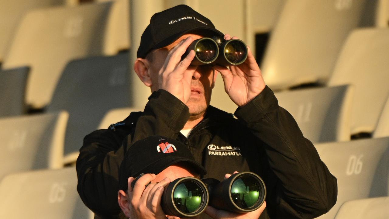 Chris Waller watches Militarize and Fangirl go through their paces through his binoculars. Picture: Vince Caligiuri/Getty Images