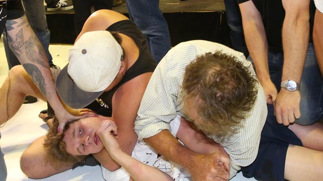 Fraser Anning’s supporters hold down Will Connolly, aka Egg Boy, after he smashed an egg over the senator’s head on March 16. Picture: AAP