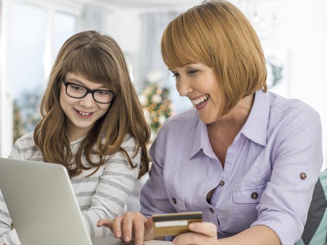 Cheerful mother and daughter shopping online at home during Christmas