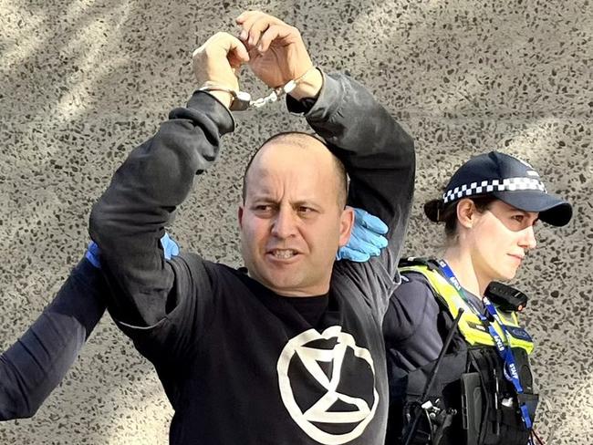 Protester who scaled Melbourne's Art Centre was arrested by Victoria Police. Picture: Jane Morton / Twitter