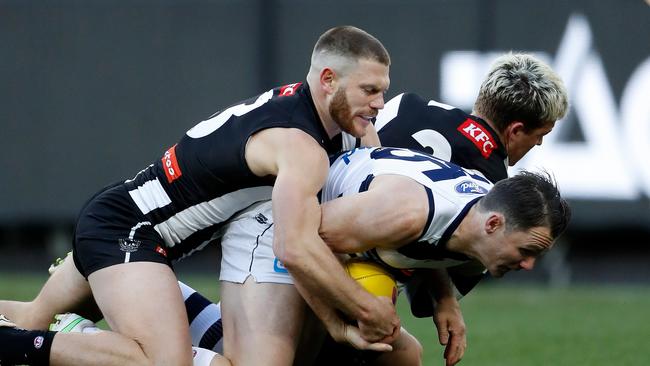 Patrick Dangerfield is tackled by Taylor Adams and Jack Ginnivan. Picture: Dylan Burns/AFL Photos via Getty Images