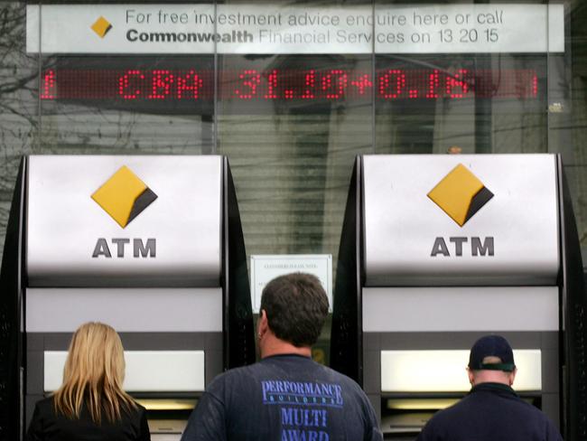 Customers use automatic teller machines (ATM) outside a branch of Commonwealth Bank of Australia (CBA). Picture: AFP