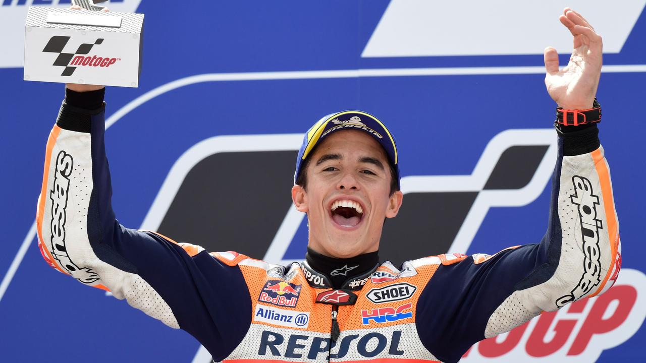 Marc Marquez celebrates with the trophy on the podium in Aragon.
