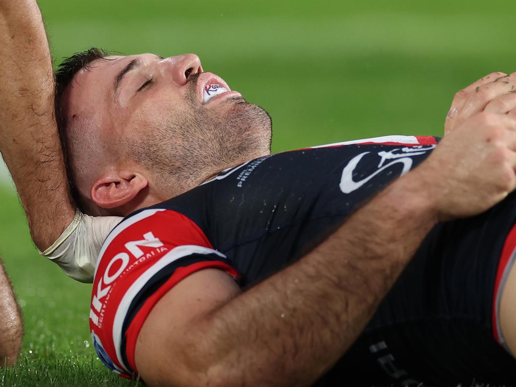 James Tedesco of the Roosters is attended to by a trainer after an attempted tackle on Viliame Kikau. Picture: Cameron Spencer/Getty Images