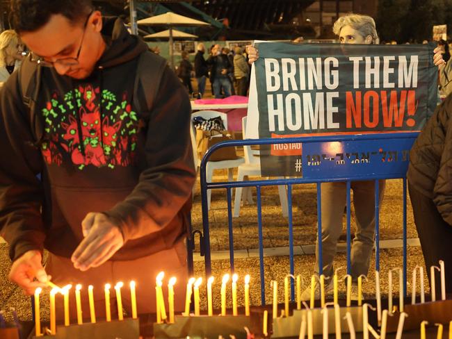 People light candles on a large menorah, to mark the end of Hanukah in Tel Aviv on January 1, 2025, during the ongoing war between Israel and Hamas militants in the Gaza Strip. (Photo by Jack GUEZ / AFP)