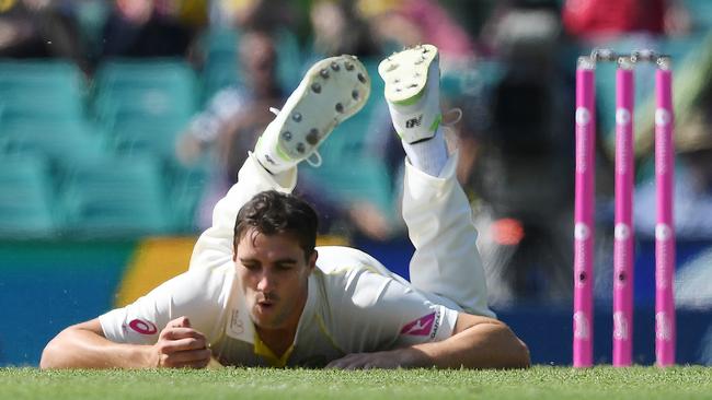 Australia's Pat Cummins reacts after catching a return ball from England's Joe Root. Picture: AAP